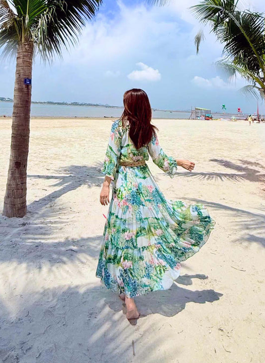 Váy maxi đi tiệc và đầm đi du lịch nghỉ dưỡng họa tiết hoa diên vĩ tông xanh biển dáng dài tay bồng thướt tha phối trong bối cảnh nghỉ dưỡng holiday sang trọng góc chụp phía sau