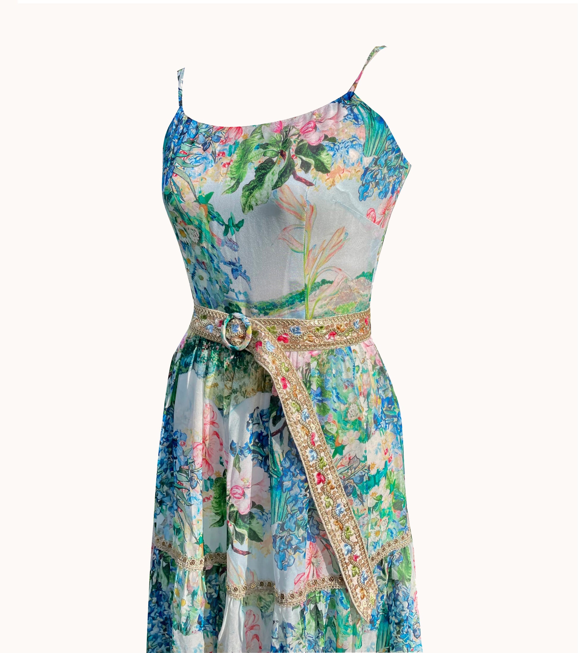 Váy maxi hai dây và đầm đi du lịch nghỉ dưỡng hoa diên vĩ màu xanh mát, cận cảnh chi tiết đường viền cổ và đai thắt eo đính kim sa thủ công lấp lánh tinh xảo
