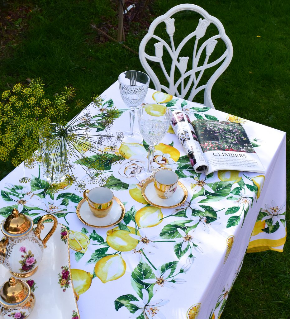 Khăn trải bàn cao cấp vải dáng chữ nhật họa tiết chanh vàng Tuscany Lemon Rose phối cùng bộ ly chén viền mạ vàng châu Âu, chụp từ trên cao xuống

