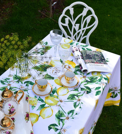 Khăn trải bàn cao cấp vải dáng chữ nhật họa tiết chanh vàng Tuscany Lemon Rose phối cùng bộ ly chén viền mạ vàng châu Âu, chụp từ trên cao xuống

